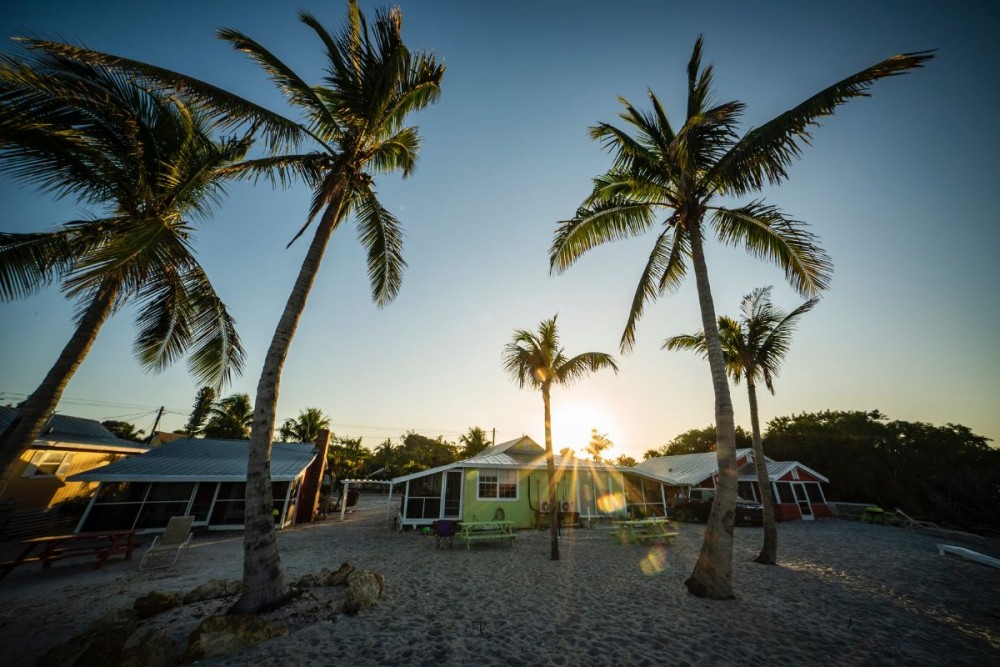 Sanibel Island beach with palms and houses on sunset